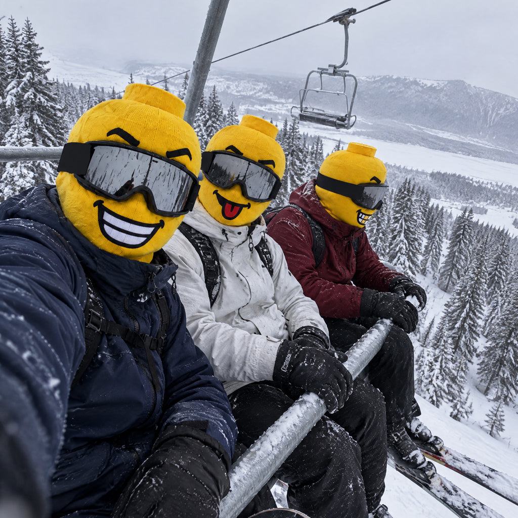 Three friends on a chairlift wearing yellow block head ski masks with goggles down
